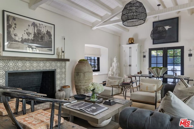 living room with vaulted ceiling with beams, french doors, and a tile fireplace