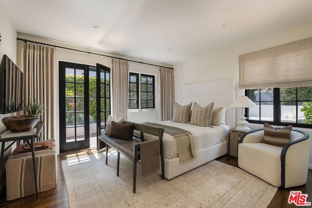 bedroom featuring french doors, wood-type flooring, and access to outside