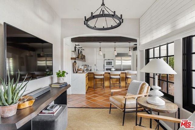 tiled living room featuring sink and an inviting chandelier