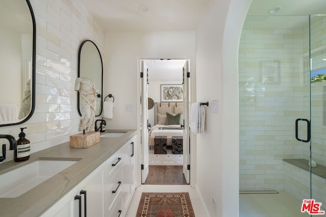 bathroom featuring an enclosed shower, vanity, and tasteful backsplash