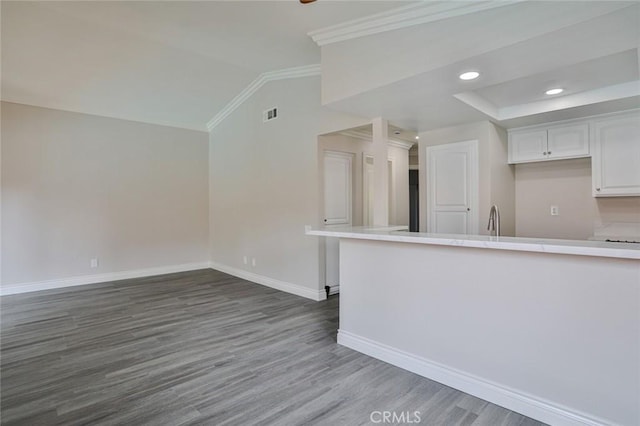 kitchen featuring white cabinetry, sink, dark wood-type flooring, vaulted ceiling, and ornamental molding