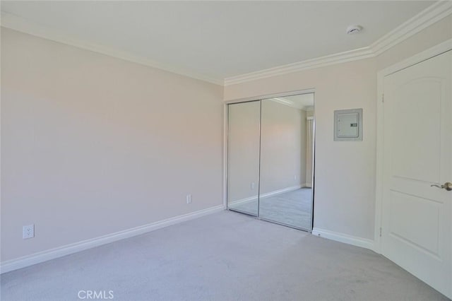 unfurnished bedroom featuring light carpet, a closet, and ornamental molding