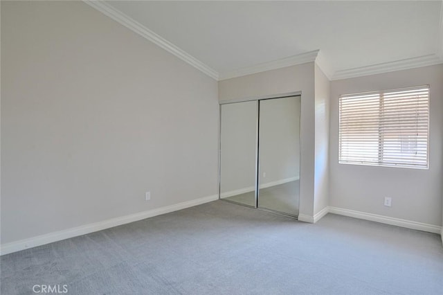 unfurnished bedroom with ornamental molding, carpet floors, and a closet