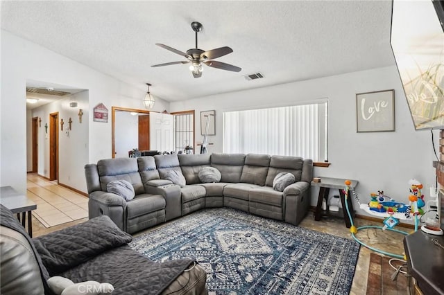 living room with a textured ceiling, light hardwood / wood-style floors, ceiling fan, and lofted ceiling