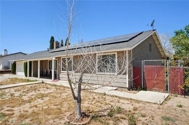 view of front of home featuring solar panels and a garage