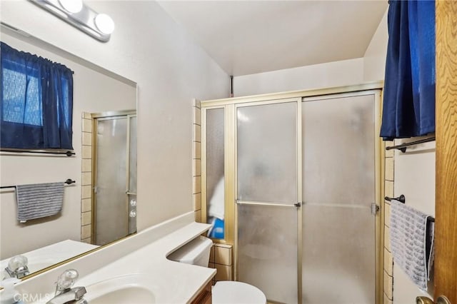 bathroom with vanity, toilet, and a shower with shower door