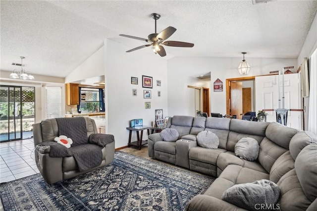 living room featuring a textured ceiling, ceiling fan with notable chandelier, vaulted ceiling, and tile patterned floors