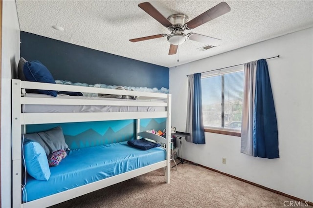 bedroom featuring ceiling fan, carpet, and a textured ceiling