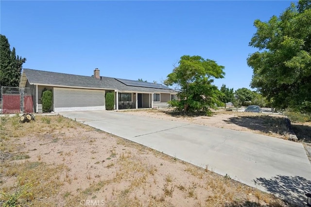 single story home featuring a garage and solar panels