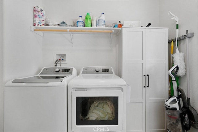 washroom with washer and clothes dryer and cabinets