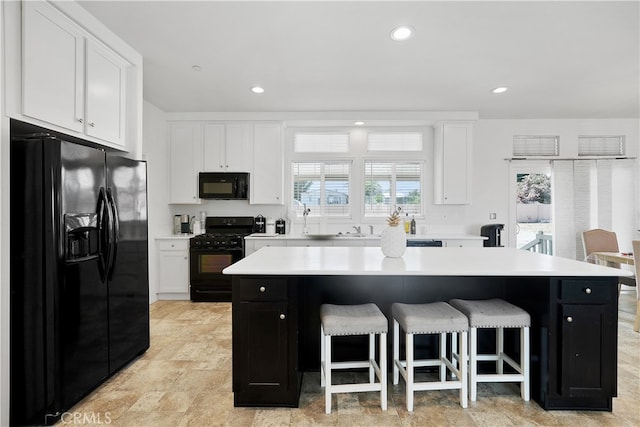 kitchen with a center island, black appliances, and plenty of natural light