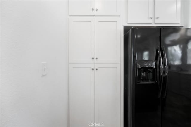 room details with white cabinetry and black fridge