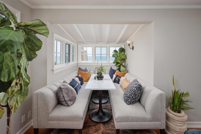 living room with breakfast area, hardwood / wood-style floors, vaulted ceiling with beams, and ornamental molding