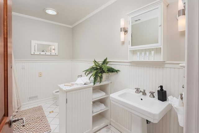 bathroom with sink, toilet, crown molding, and tile patterned flooring