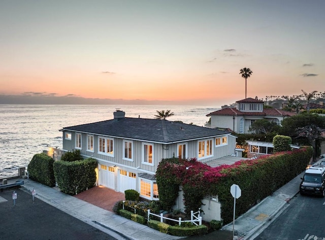 view of front of house featuring a garage and a water view