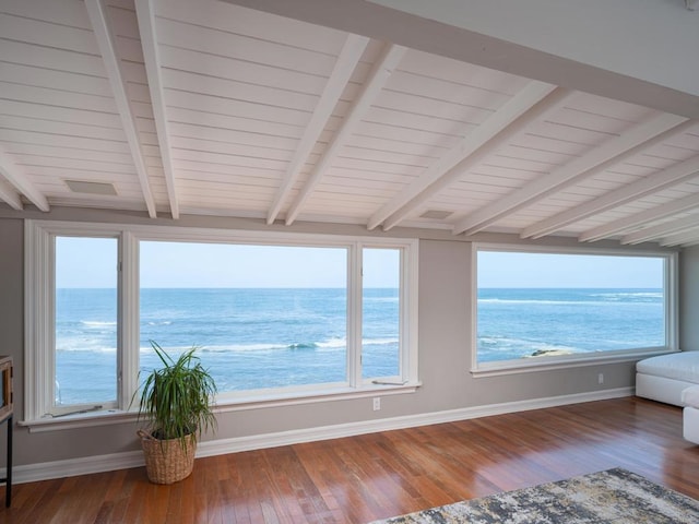 unfurnished sunroom featuring a water view and beam ceiling