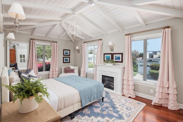 bedroom with a fireplace, multiple windows, dark hardwood / wood-style floors, and an inviting chandelier