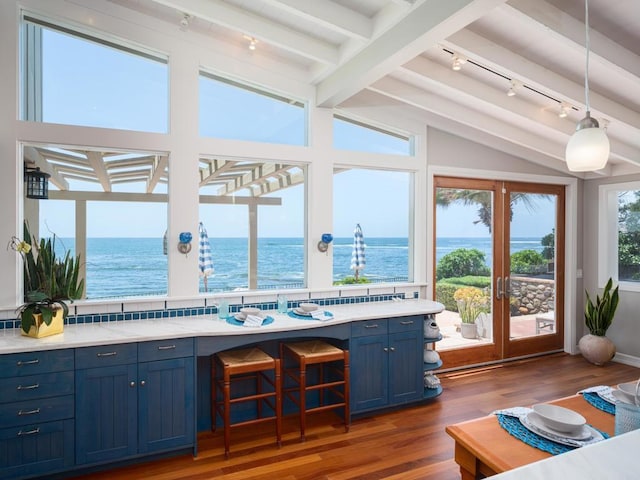 sunroom / solarium featuring lofted ceiling with beams, a water view, and french doors