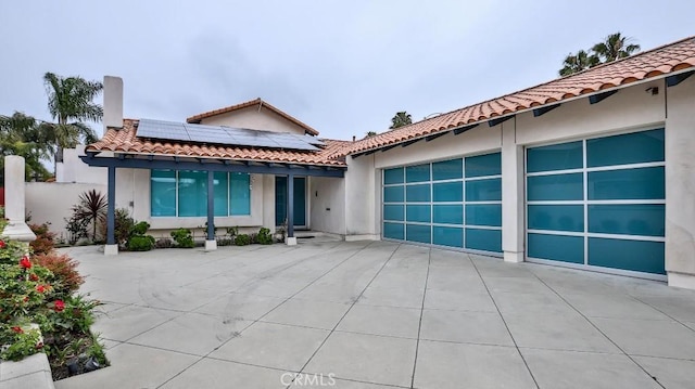 view of front of house featuring solar panels and a garage