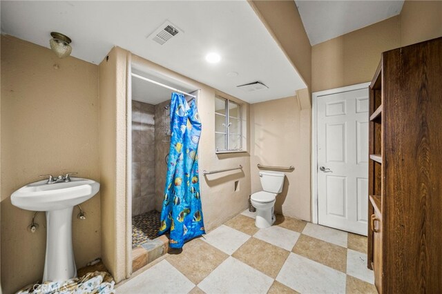 bathroom featuring a shower with curtain, toilet, and sink