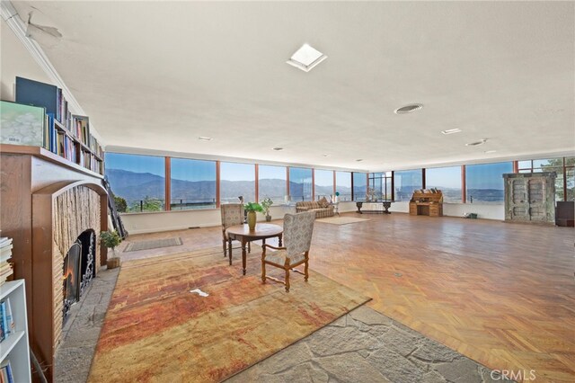 interior space featuring a mountain view, crown molding, parquet floors, and a wall of windows