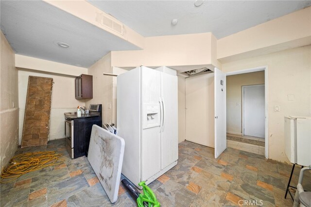 kitchen featuring dark brown cabinetry, stainless steel range with electric stovetop, and white refrigerator with ice dispenser