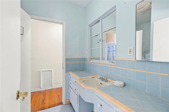 bathroom with vanity, wood-type flooring, and tile walls