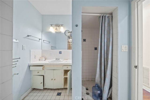 bathroom featuring tile patterned floors, decorative backsplash, a shower with shower curtain, and vanity