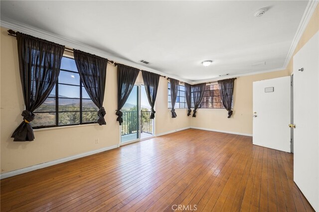 unfurnished room with hardwood / wood-style flooring and ornamental molding