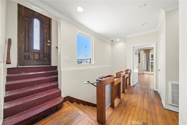 entrance foyer with crown molding and hardwood / wood-style flooring