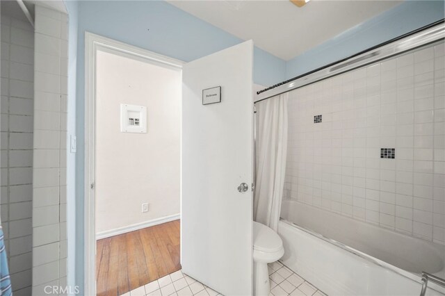 bathroom with wood-type flooring, shower / tub combo, and toilet