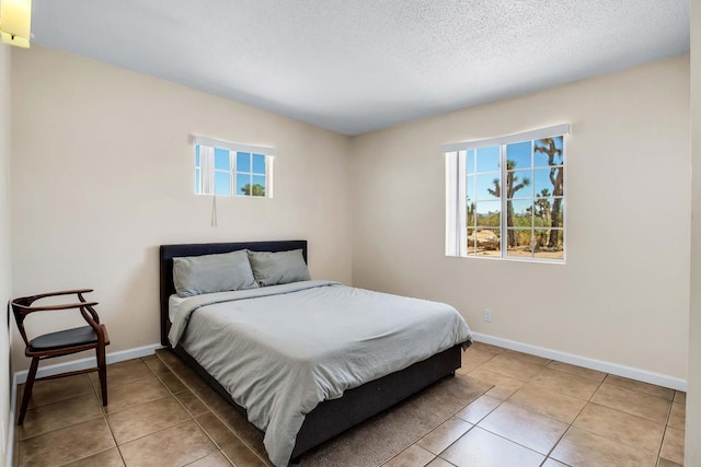 tiled bedroom featuring a textured ceiling