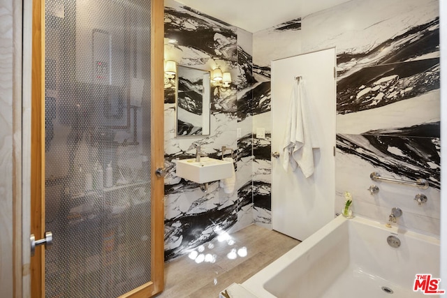 bathroom featuring a bathtub, sink, and tile walls