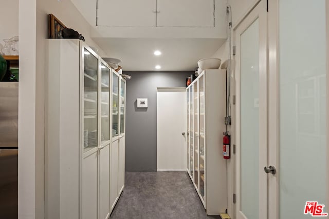 hallway featuring dark colored carpet