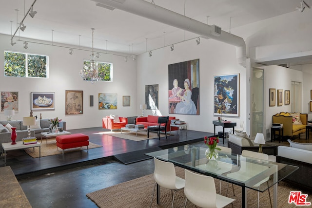 dining room with rail lighting, a towering ceiling, and plenty of natural light