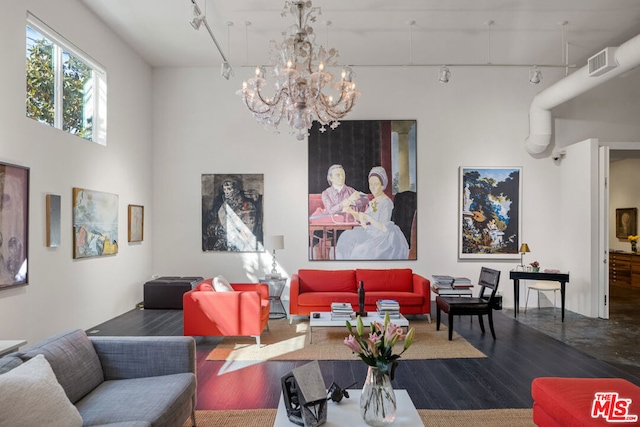 living room featuring an inviting chandelier, rail lighting, and dark hardwood / wood-style flooring