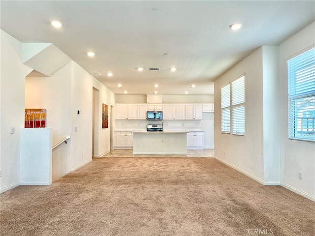 unfurnished living room featuring light carpet