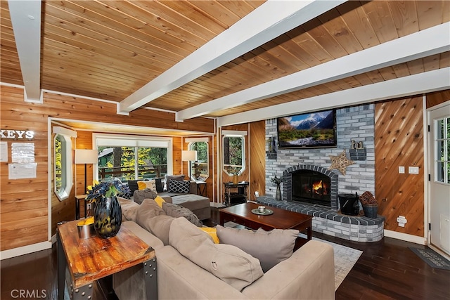 living room with a brick fireplace, wooden ceiling, wooden walls, beam ceiling, and dark hardwood / wood-style floors