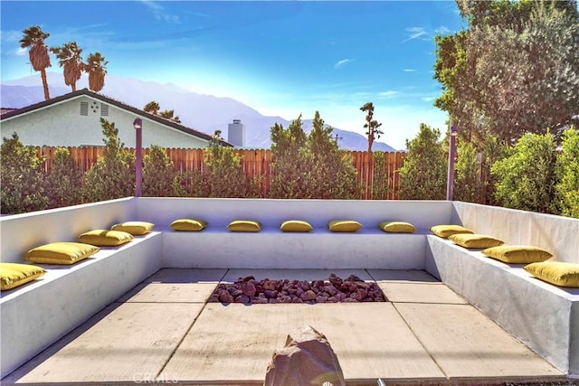 view of patio with fence and a mountain view