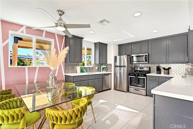 kitchen with visible vents, appliances with stainless steel finishes, light countertops, gray cabinetry, and a sink