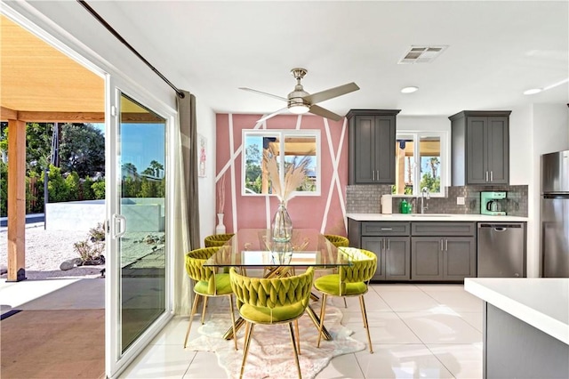 kitchen featuring visible vents, decorative backsplash, appliances with stainless steel finishes, light countertops, and a sink