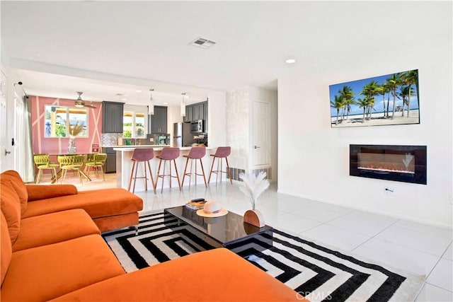 living area with light tile patterned floors, visible vents, and recessed lighting