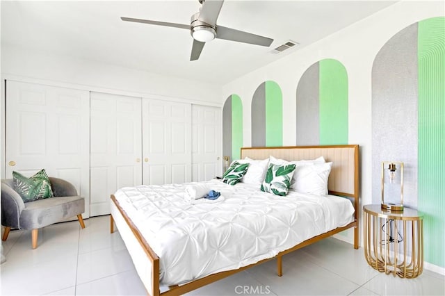 bedroom featuring light tile patterned floors, ceiling fan, visible vents, and a closet