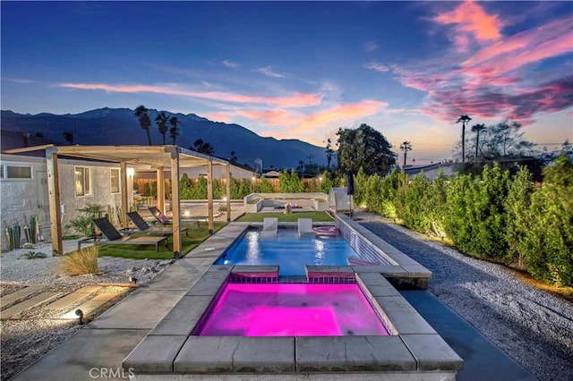 view of swimming pool featuring a patio area, a mountain view, and an in ground hot tub