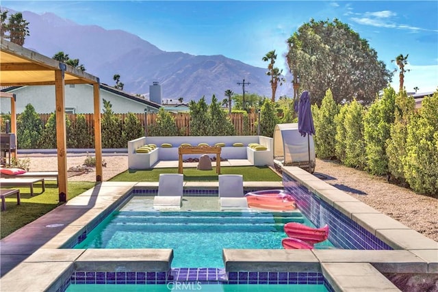 view of swimming pool featuring a fenced in pool, an in ground hot tub, fence, a mountain view, and an outdoor living space