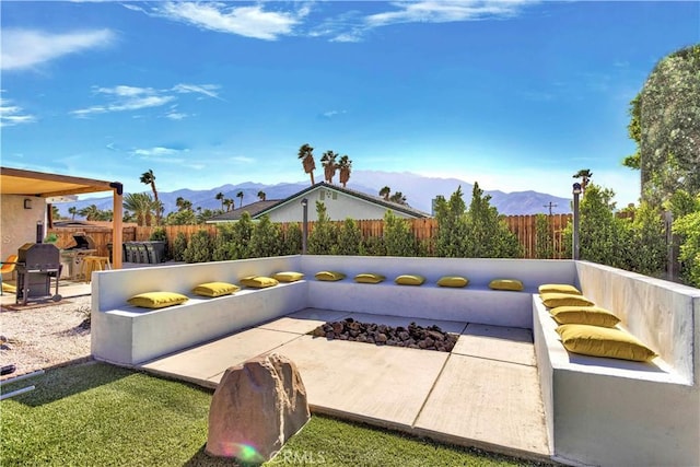 view of patio / terrace featuring grilling area, fence, and a mountain view