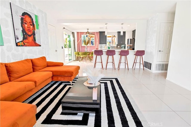 living area with visible vents, baseboards, and tile patterned floors