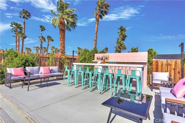 view of patio featuring fence private yard, an outdoor hangout area, and outdoor dry bar