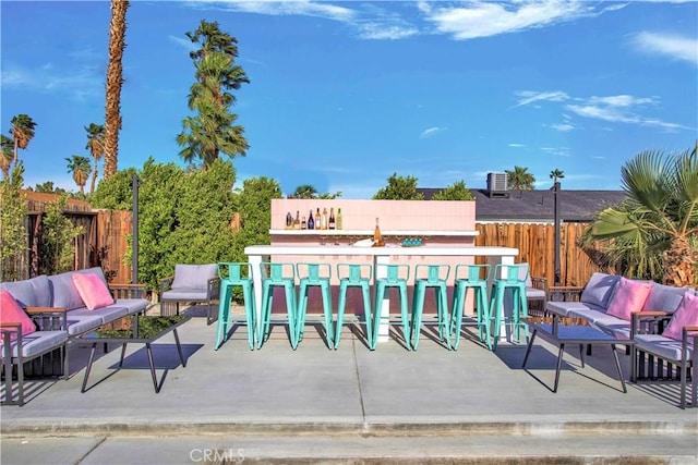 exterior space featuring fence, outdoor dry bar, and an outdoor living space