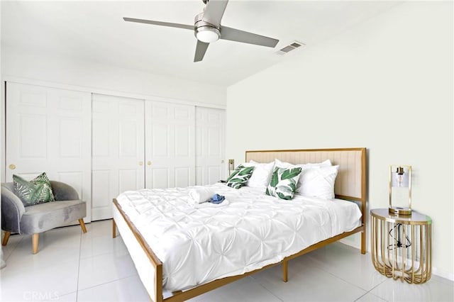 bedroom with light tile patterned floors, ceiling fan, visible vents, and a closet